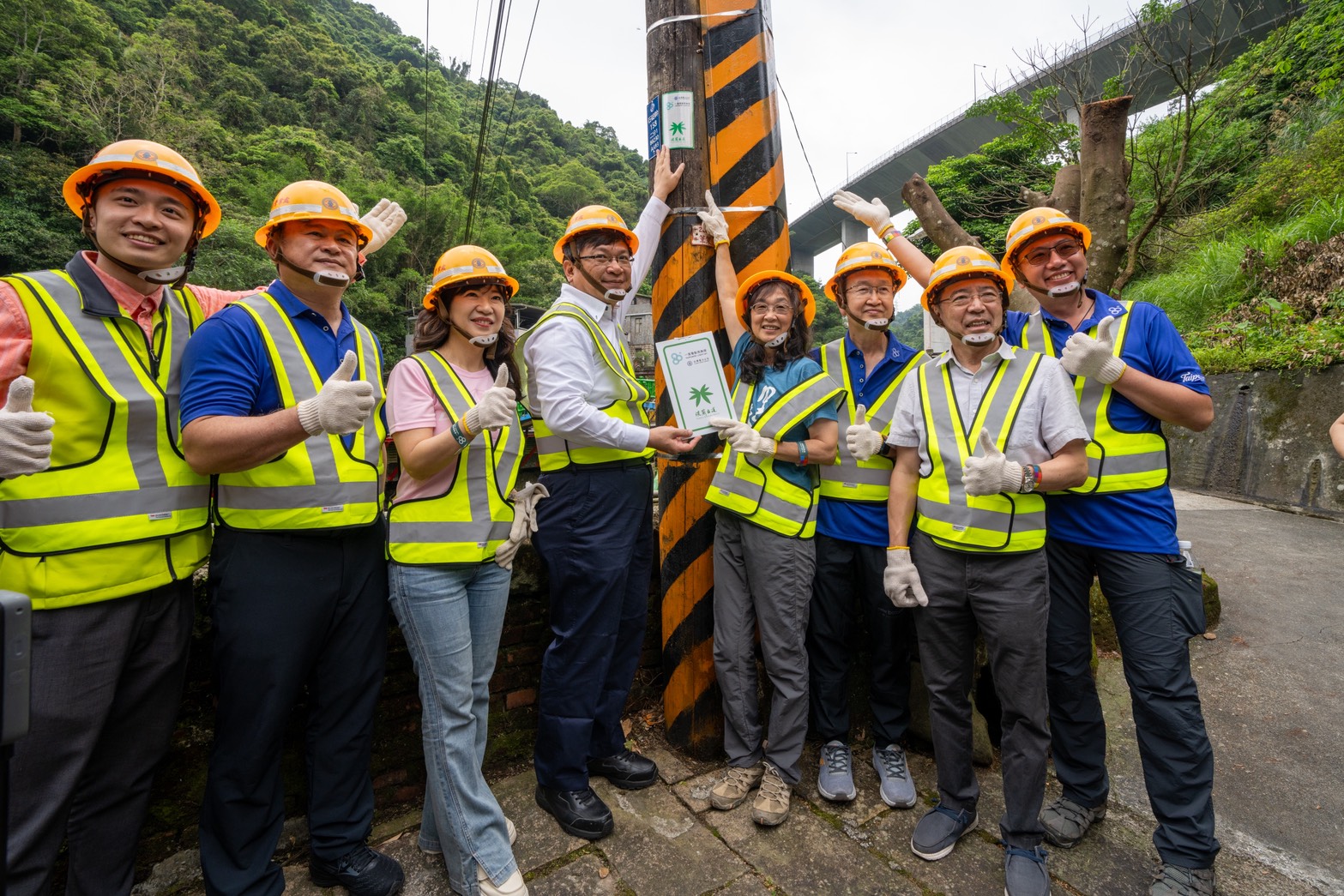 台電攜手千里步道協會，於淡蘭古道、樟之細路與山海圳等3條國家級綠道沿線電桿掛設專屬識別引路指示牌，今（18）日於新北市石碇國小後方的石碇幹電桿舉行揭牌儀式。（左起為新北市議員陳永福辦公室代表陳韋任、台電工會理事長吳有彬、新北市經濟發展局局長盛筱蓉、台電董事長曾文生、千里步道協會執行長周聖心、台電總經理王耀庭、台灣電力與能源工程協會理事長劉文雄、台電勞工董事林政良）